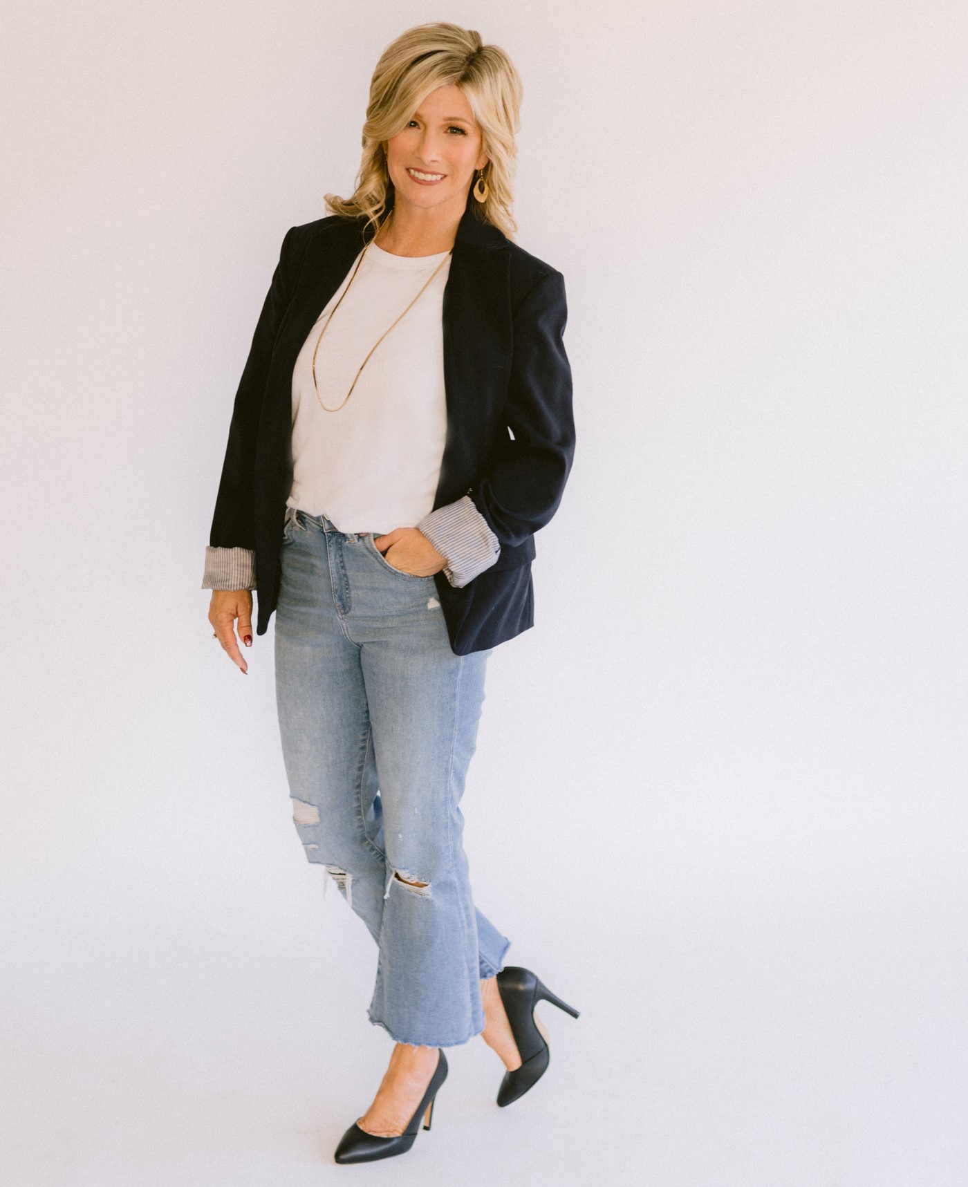 Realtor Danielle Nunes wearing blue jeans, navy blazer, white blouse, with black heels